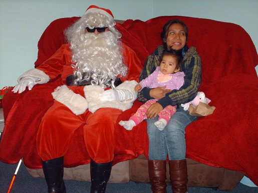 Blind Santa sitting with a mother and her child